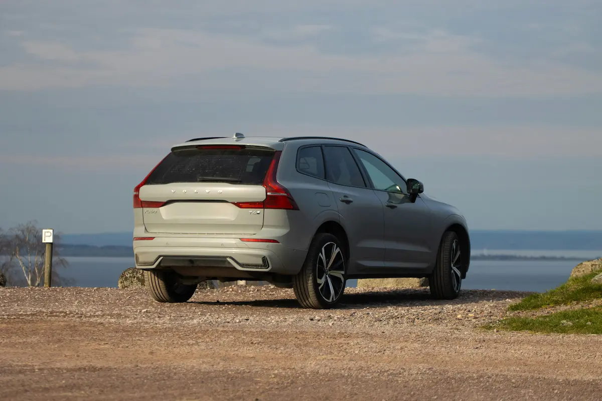 Volvo car driving on a tree-lined road